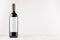 Dark wine bottle with blank white label on white wooden board, mock up.