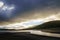 Dark winter landscape with fresh water lake, mountains on the horizon and dark clouds in the sky. Lozoya Reservoir, Madrid