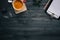 Dark wood office desk table with blank notebook, supplies and coffee cup. Top view with copy space. Flat lay