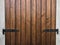 Dark wood plank background with black metal details. Closed window shutters close-up. Background. Copy space. Vertical wooden plan