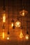 On a dark wooden background hang burning light bulbs of different shapes