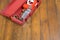 On a dark wooden background, a red box with a soldering iron and a set of nozzles for the repair and construction of plastic pipes