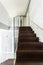 Dark wooden staircase with transparent railing