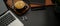 Dark worktable with laptop, schedule books, coffee cup, wireless earphone and copy space