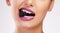 The darker the berry the sweeter the juice. Cropped shot of an attractive woman wearing purple lipstick and biting a