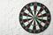 Dart board with arrows hitting target on white  wall. Space for text