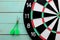 Dart board with two darts lies on a wooden background