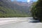 Dart River with people in the distance who do rafting along the river, New Zealand