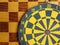 Dartboard with cards and dice on chessboard