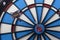 Dartboard with two darts, one hit bullseye spot on