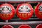 Daruma dolls. The Japanese lucky symbolic dolls hanging in the row with text translation â€œfortune