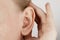 Darwin`s tubercle on the ear. The girl at the reception at the plastic surgeon, shows the auricle