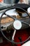 Dashboard of old car with steering wheel and cap of driver