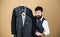 Dashing mens fashion and style. Fashion designer helping to choose suit jacket. Fashion stylist holding readymade coats