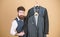 Dashing mens fashion and style. Fashion designer helping to choose suit jacket. Fashion stylist holding readymade coats