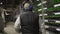 Data center diagnostics technician walks along the mining equipment racks in server room. Network administrator checks