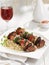 Date and bacon wrapped pork brochettes with vegetables