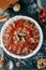 Date cake with sweet jam and shortbread. Fruit cake cut into slices close-up on a dark table