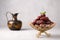 Date Fruits or Kurma in vintage arabic dish and jug of water at grey concrete backdrop. Dates and water is Ramadan food