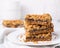 Date squares or Matrimonial cake stacked on a plate in a white kitchen