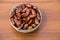 Dates fruit on silver bowl on wooden table. The Muslim feast of the holy month of Ramadan Kareem