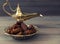 Dates and golden arabian lamp on wooden background