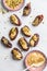 Dates stuffed with peanut butter, chocolate and pistachios on white background