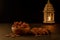 Dates in wooden bowl and lantern on stone table. Muslim holy month Ramadan Kareem. Copy space