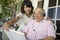 Daughter Assisting Father In Using Laptop At Porch