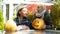 Daughter bringing pumpkin jack-o-lantern to mother, preparation for Halloween