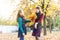 The daughter congratulates her mother and gives her an autumn bouquet of yellow leaves