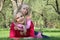 Daughter embraces mother lying on grass