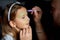 Daughter and father paint a face, having fun, leisure together at home