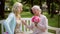 Daughter with flowers and gift for senior mother