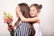 Daughter gives flowers to her mother on her mother`s day