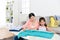 Daughter helping mother folding family clothing