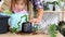 Daughter helps mom transplants home plants, plants sansevieria into a new soil and pot. Mom teaches taking care of potted plants.