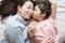 Daughter kisses her mother`s cheek. and hugging in the bedroom .Happy Asian family.