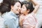 Daughter kisses her mother`s cheek. and hugging in the bedroom .Happy Asian family.