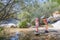 Daughter with loupe and her mother discovering nature in a river of Camorza Gorge near Madrid