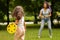 Daughter with mom play frisbee in the park, happy active family holidays, outdoor game