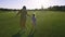 Daughter and mom running on green grass meadow