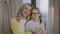 Daughter and mother casual portrait at home Rbbro. Smiling relaxed family of 30s blonde woman