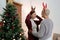 Daughter and mother caucasian wearing deer antler headband and Christmas tree to prepare for family's Christmas Day