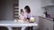 Daughter and mother cook together in the kitchen, daughter helps mother knead dough for pancakes or cookies. Kitchen