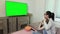 Daughter and mother watching TV with green screen