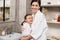 daughter and mother in white bathrobes hugging and smiling