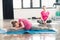 Daughter in pink shirts stretching with mother in lotos pose behind in gym