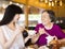 Daughter and senior mother enjoy eating in restaurant