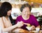 Daughter and senior mother enjoy eating in restaurant